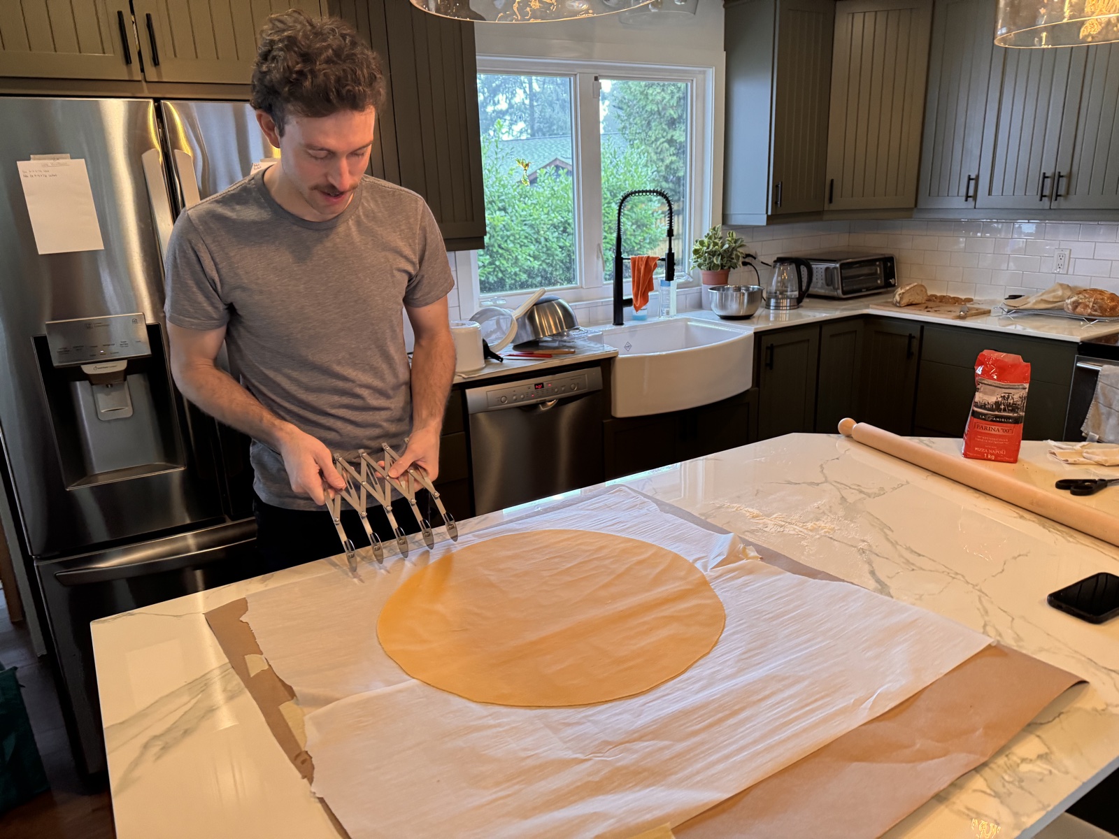 Rolling out a sheet of fresh pasta dough by hand in a home kitchen.